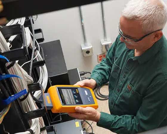 technician using a rented low voltage tester on cabling